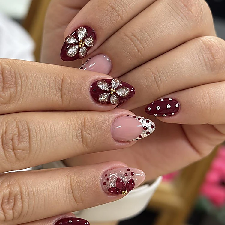 Uñas en borgoña y nude con flores de brillo y piedras