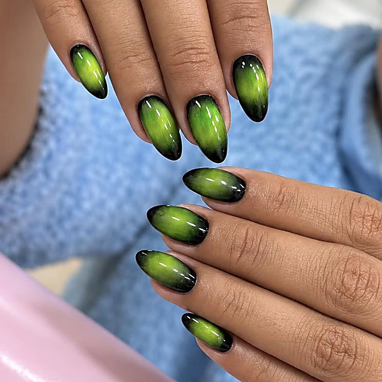 Uñas almendra cat-eye en verde intenso con puntas negras