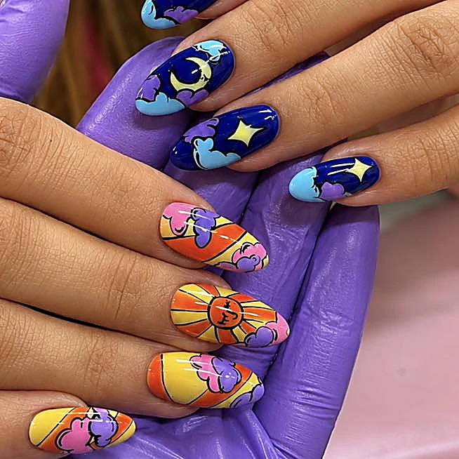 Uñas pintadas a mano con luna, estrellas, nubes y un sol en azul, naranja y lila