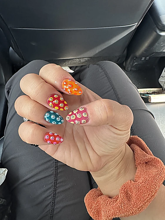 Uñas con flores en naranja, rojo y azul sobre base coral