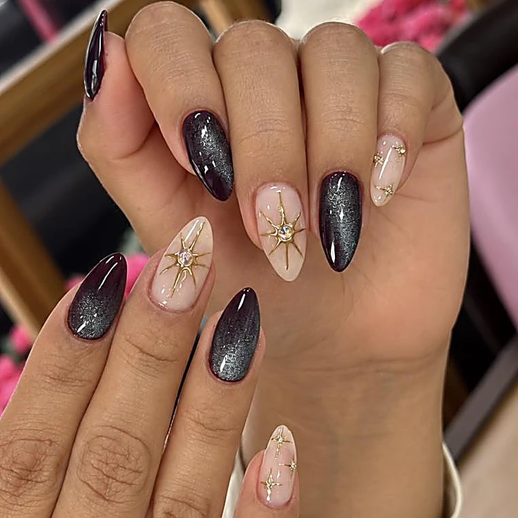 Uñas en negro cat-eye combinadas con nude y estrellas doradas
