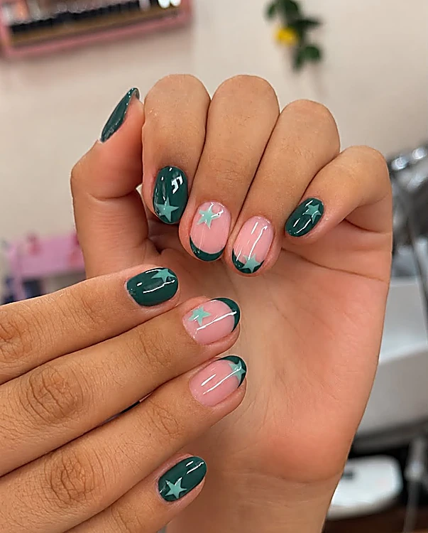 Uñas verde bosque combinadas con francés rosa y una estrella